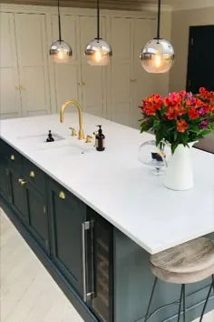 جزیره آشپزخانه سبز تیره با میز کار سفید ، سینک ظرفشویی و اتصالات طلایی