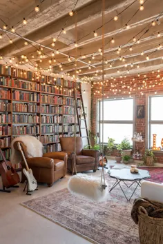 قفسه کتاب از کف تا سقف با پس زمینه دیوار آجری در کنار آن و نور رشته ای درخشان - Decoist