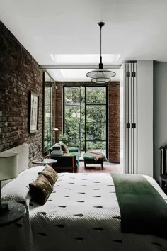 اتاق خواب با نورگیرها و دیوارهای آجری نمایان در یک خانه تراس فرسوده که توسط طراح برای خود در لندن ، انگلستان مرمت و بازسازی شده است [1920 12 1280]