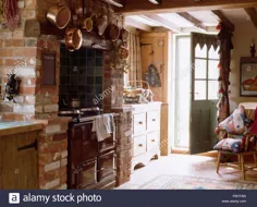 عکس - سیاه آقا در شومینه آجری در آشپزخانه کلبه