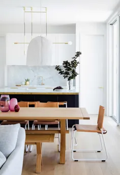 خانه ای به سبک هامپتون با آشپزخانه تمام سفید و فضای غذاخوری چوبی