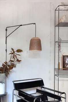 چراغ دیواری PET Lamp در گوشه ای از استودیوی آرام بالای یک صندلی طراح
