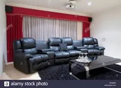 عکس - اتاق سینمای خانگی با صندلی های تکیه دار چرم مشکی ، پرده های قرمز ، فرش سیاه و میز با لیوان های نوشیدنی