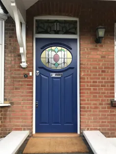 درب ورودی رویال آبی با شیشه های رنگی و ترانس  تر و تمیز سفید  خانه آجر قرمز.