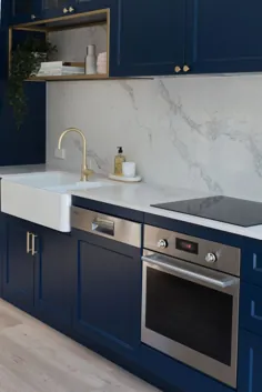آشپزخانه آبی سرمه ای با لهجه های برنجی لوکس و نیمکتی مرمر