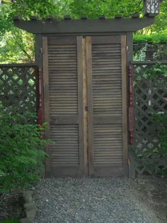 یک جفت درب کرکره ای بازیافتی قدیمی به عنوان دروازه باغ به حیاط پشتی آویزان است!