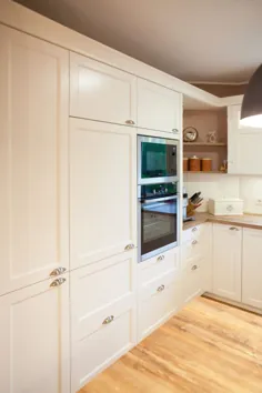 Moderne Landhausküche in weiß von Häcker Küchen mit Kochinsel ، BORA Kochfeld und NEFF Elektrogeräten - Küchenhaus Thiemann Overath / Vilkerath