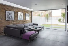 کاناپه های بزرگ خاکستری ، دیوارهای آجری و شیشه ای یک اتاق نشیمن معاصر و دوست داشتنی ایجاد می کنند [از: IQ Glass UK] - Decoist