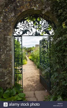 عکس - دروازه تزئینی آهن فرفورژه و ورودی طاق سنگی Cotswold به باغ دیواری خانه Rousham