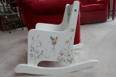 صندلی گهواره ای کودکانه که با جن های گل ، گل های وحشی و پروانه ها نقاشی شده است