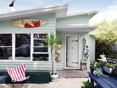 خانه ساحلی کودک آبی آبی با سنگریزه و گیاهان با میز چوبی دریایی و تزئینات پنجره سفید
