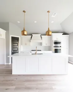 آشپزخانه سفید با چراغ های آویز طلای مدرن ، کوارتز سفید ، چوب های سخت ، + درب داخلی مشکی