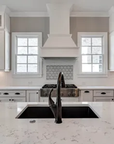 پیشخوان آشپزخانه کوارتز مرمر با کابینت های شیکر سفید و هود سفارشی با طیف سفید.  سینک ظرفشویی