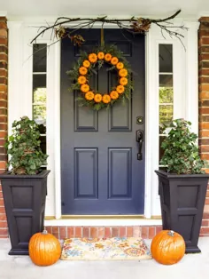 درب ورودی آبی تیره با تاج گل نارنجی.  خانه آجر قرمز.