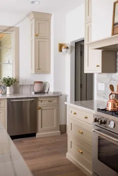 کابینت های بژ + سخت افزار برنجی جذابیت را به یک آشپزخانه سنتی می رساند