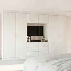 کمد سفید مجهز به تلویزیون در یک اتاق خواب مدرن و مجهز