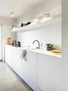 آشپزخانه سفید مدرن سبک و ظرافت را نشان می دهد ، ترکیبی از مدرنیته و عملکرد است