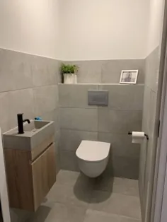 توالت مدرن با کاشی های بتونی و مبلمان دستشویی چوبی