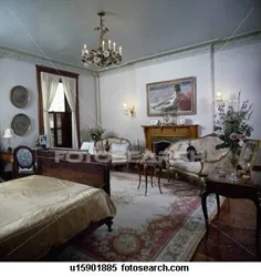 مبلمان عتیقه فرانسوی در اتاق خواب سنتی با فرش ابریشم چینی و لوستر برنجی تزئینی Stock Stock |  u15901885