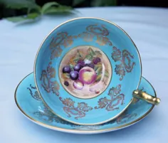 فنجان چای عتیقه Aynsley و نعلبکی.  سرویس چای استخوان چین فیروزه ای.  میوه درون فنجان توسط D. Jones رنگ آمیزی شده است.