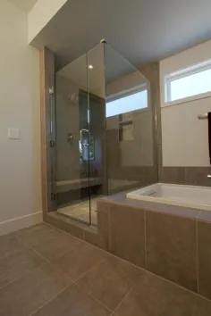 حمام آبگرم مدرن با دوش شیشه ای بزرگ در کنار وان حمام