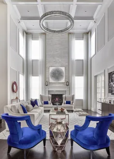 دکور اتاق نشیمن سفید و آبی زیبا با صندلی های مخملی آبی و لوستر کریستالی