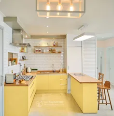 آشپزخانه سفید با کابینت های زرد روشن و شمارنده های چوب طبیعی