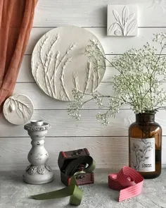 بشقاب تزئینی دیوار برجسته سه بعدی اکالیپتوس در اتاق غذاخوری خانه مزرعه.  نقش برجسته گل رس گرد از گیاهان تحت فشار.  گچ بری های گلی آشپزخانه مزرعه