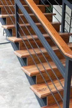 راه پله چوبی قهوه ای با نرده آهنی در خانه مدرن
