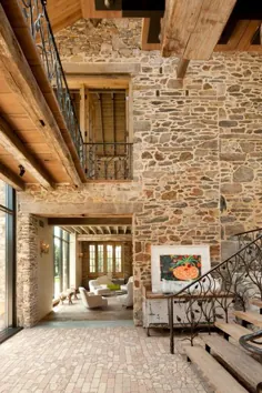 طراحی مجدد مدرن خانه قدیمی کشور با دیوارهای سنگی عتیقه و تیرهای سقفی در معرض دید