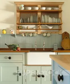 عکاسی SuperStock Stock، قفسه بشقاب چوبی در بالای غرق سفید بلفاست در آشپزخانه با واحدهای مجهز به رنگ سبز کم رنگ