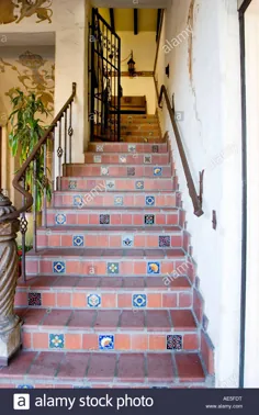 عکس Stock - راه پله به سبک اسپانیایی با گلدان و کاشی های تزئینی با نرده و دروازه آهن فرفورژه