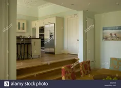 عکس عکس - اتاق ناهار خوری مدرن در سطح تقسیم شده با پله های بالا تا قسمت آشپزخانه