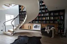 راه پله مارپیچ بدون زحمت توسط قفسه کتاب از کف تا سقف جریان می یابد