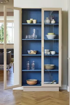 یک کابینت دو رنگ و درهای شیشه ای ظروف غذاخوری خانوادگی را در این آشپزخانه مدرن و زیبا نگهداری می کند.